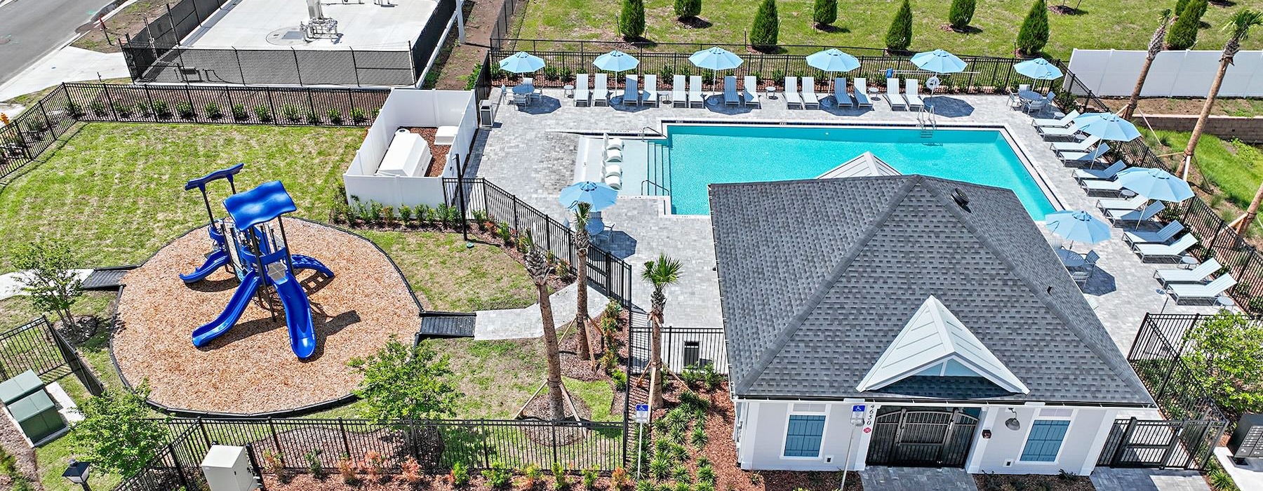 a high angle view of a swimming pool and park and clubhouse