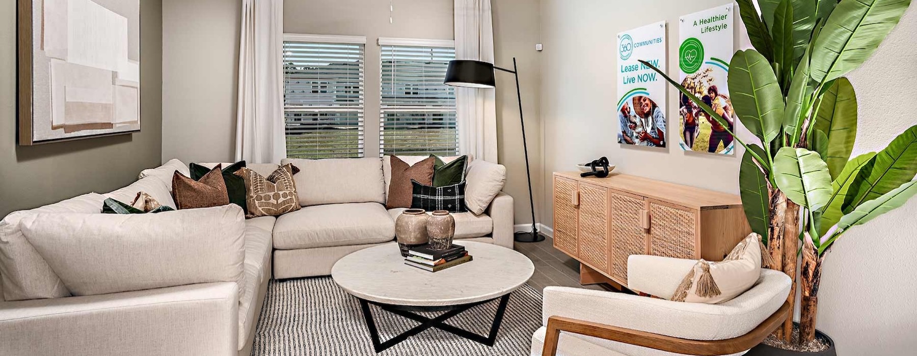 a living room with a white couch and a coffee table and window