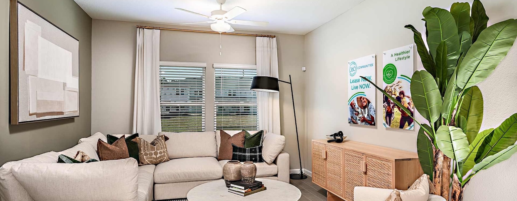 a living room with a white couch and a coffee table and window