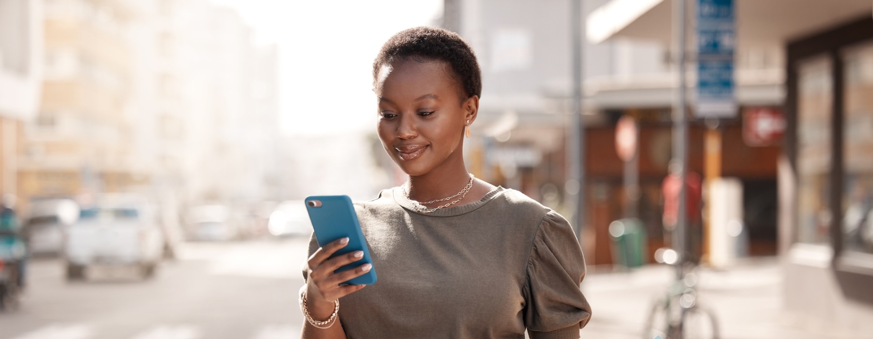 a woman shopping and looking at her smart device outside