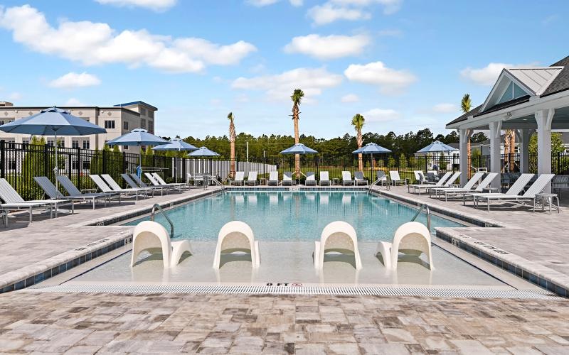 a pool with lounge chairs around it